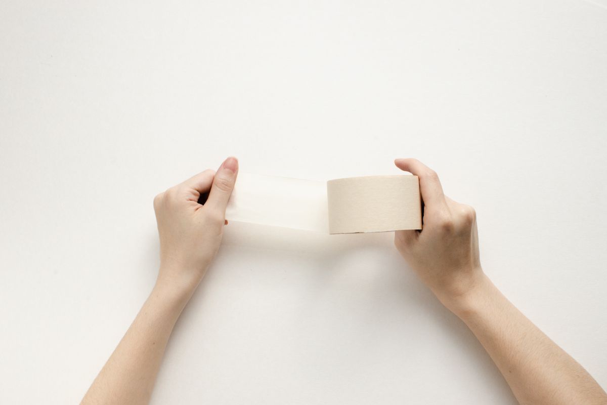 Una mujer sujetando una cinta adhesiva.