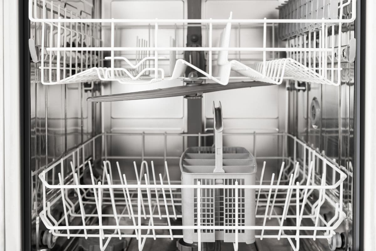 Vista interior del lavavajillas vacío con cestas blancas
