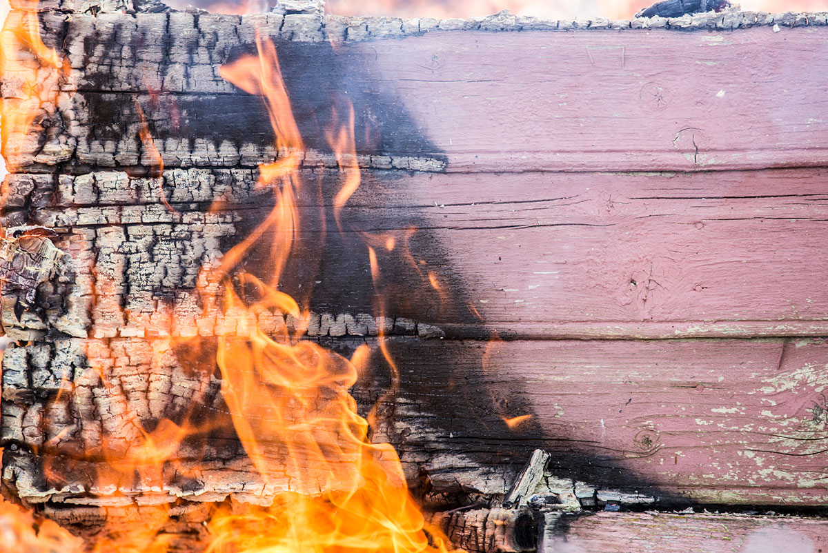 Una pieza de madera pintada ardiendo.