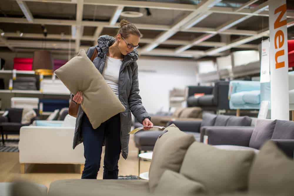 Esta es una imagen cercana de una mujer mirando sofás en una tienda de muebles.