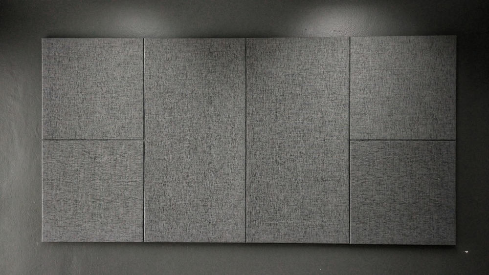 Esta es una vista cercana de una pared gris con paneles grises de insonorización.