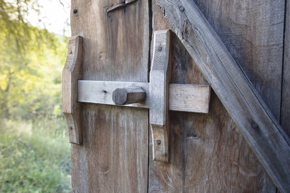 Esta es una vista de cerca de una puerta corredera de madera maciza para granero.