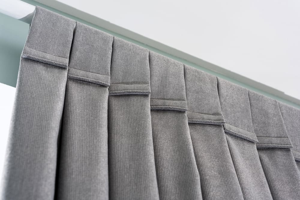 Esta es una mirada de cerca a un conjunto de cortinas grises con capacidad de insonorización.