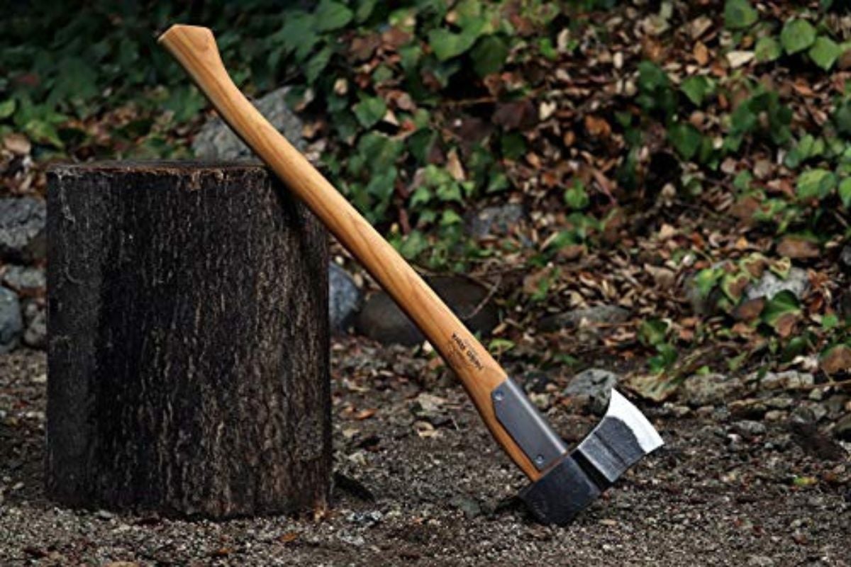Una foto de cerca de un hacha de dividir en un corte de madera.