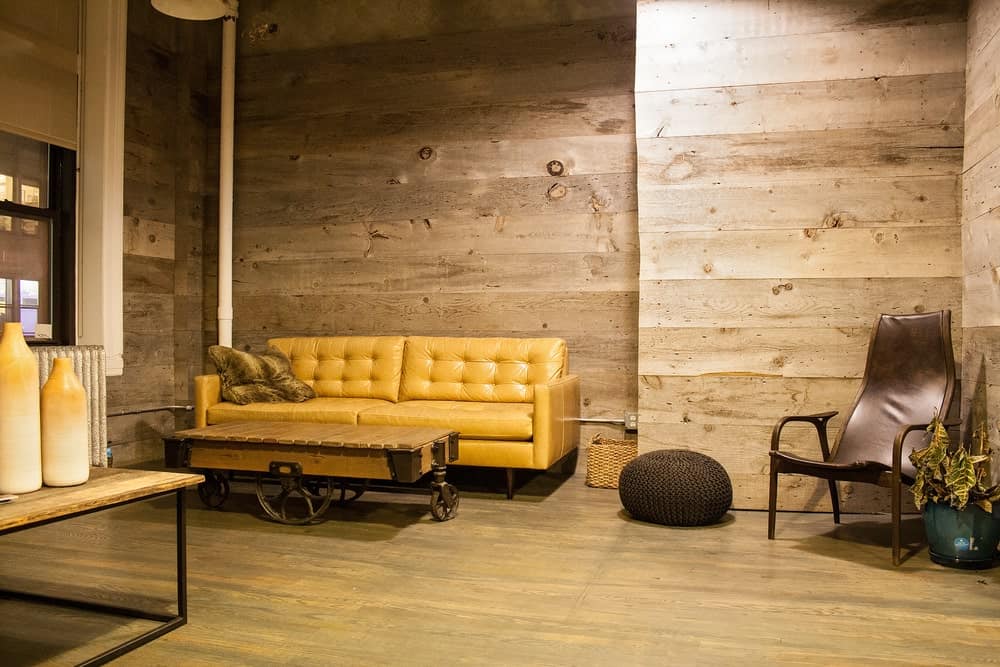Salón rústico con paredes de tablones y suelo de madera.