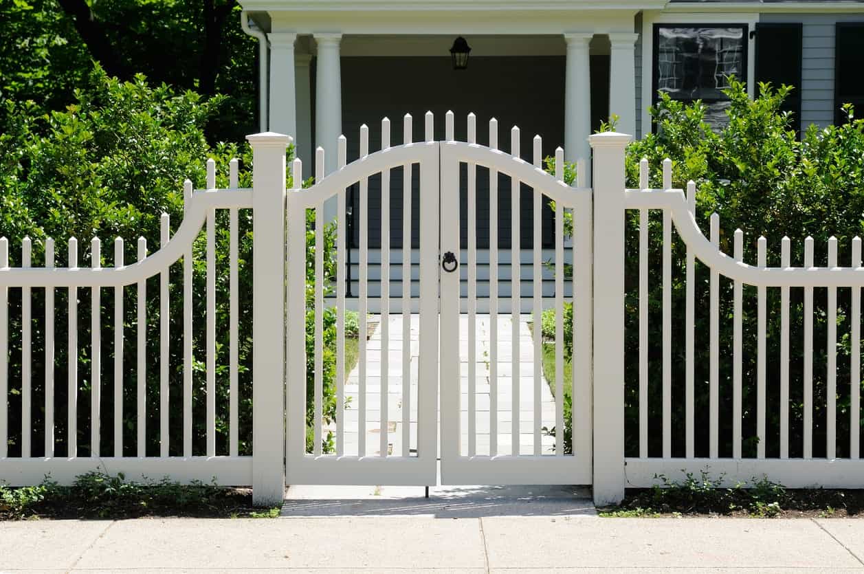 Casa con valla blanca también como puerta.