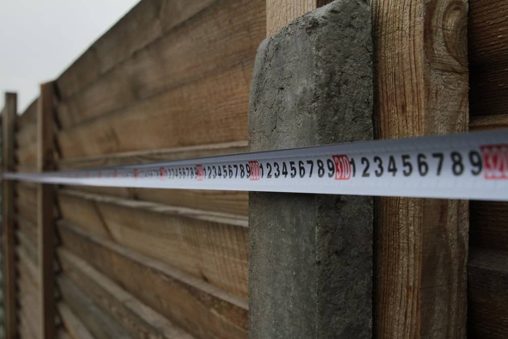 Primer plano de una cinta métrica utilizada para medir la valla de madera.