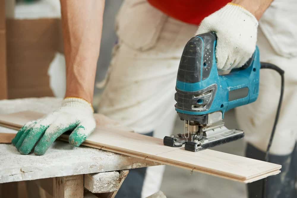 Un carpintero utiliza una sierra de calar eléctrica para obtener la forma deseada de la madera.