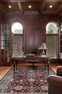 Elegante despacho en casa con suelo de madera noble. El material predominante es la madera, que le da el acabado marrón rojizo.