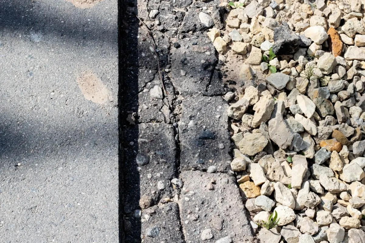 Grava de piedra triturada junto a una carretera asfaltada.