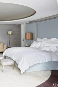 Un techo de bandeja circular es el tema de conversación en este dormitorio espacioso y elegante.