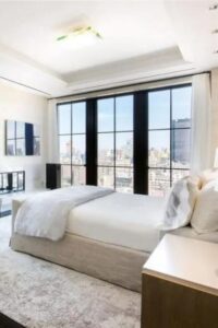 Este elegante dormitorio de estilo ático presenta una paleta de colores monocromática en diferentes texturas para crear un diseño cohesionado.