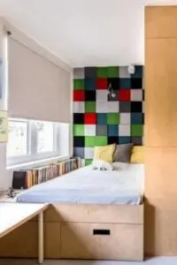 Este divertido dormitorio principal presenta una instalación artística de estilo patchwork sobre la cama empotrada y cajones de almacenaje.