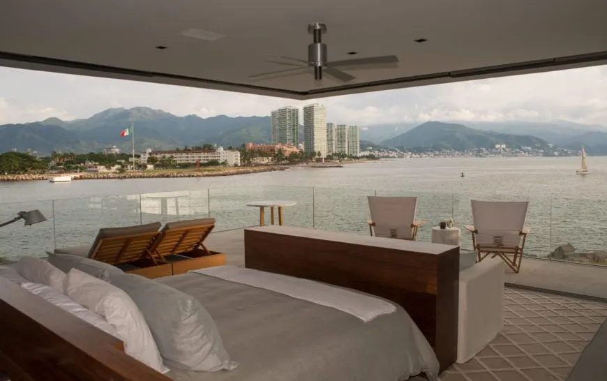Dormitorio principal personalizado con una acogedora cama y zonas de estar con vistas a los impresionantes alrededores.