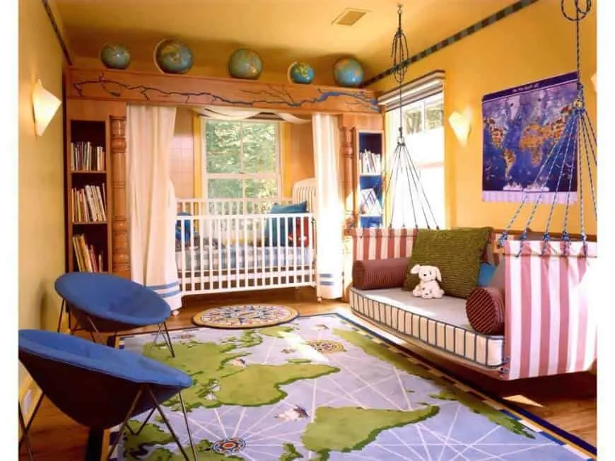 Un dormitorio infantil con un sofá giratorio a medida y una llamativa cama infantil con estanterías empotradas y modelos de globos terráqueos encima. La habitación tiene suelo de madera y una alfombra inspirada en los mapas.