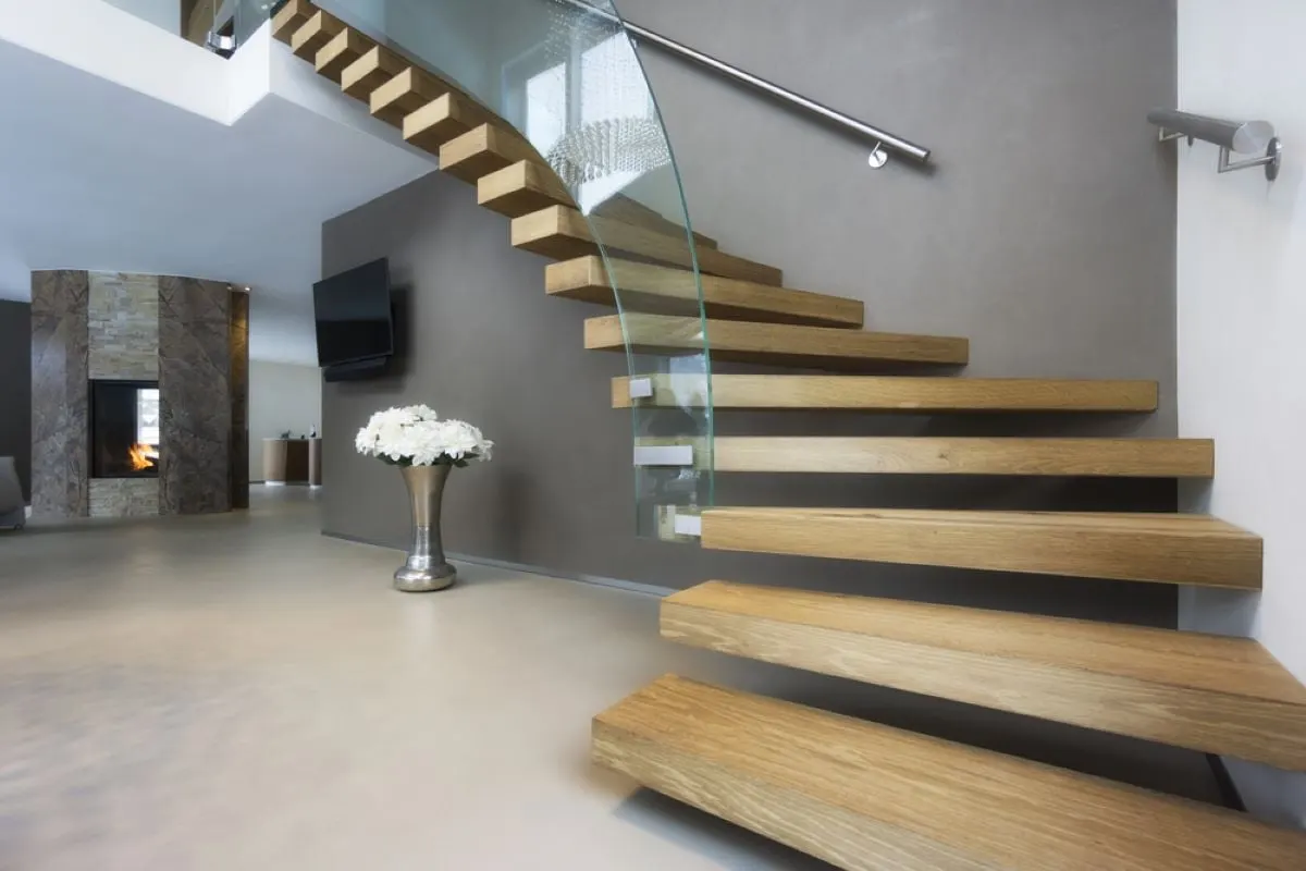 Escalera flotante de madera y cristal en casa moderna.