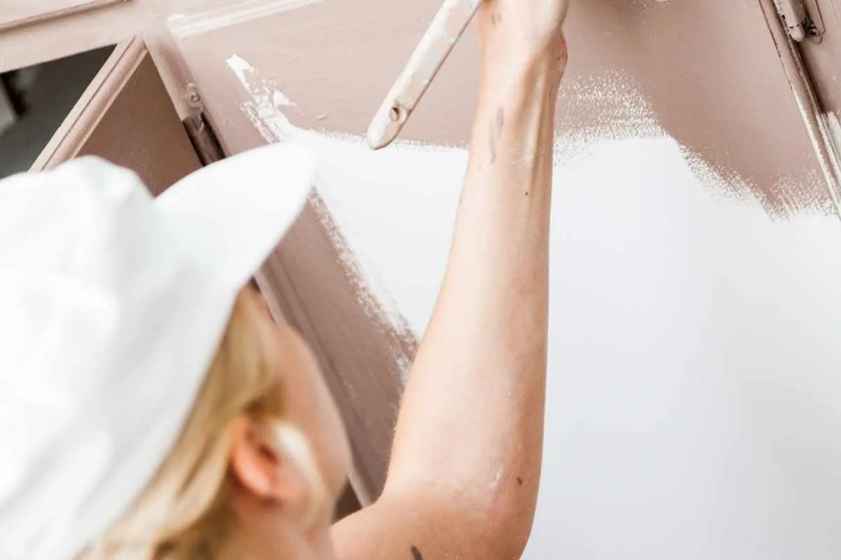 Primer plano de una mujer pintando un armario.