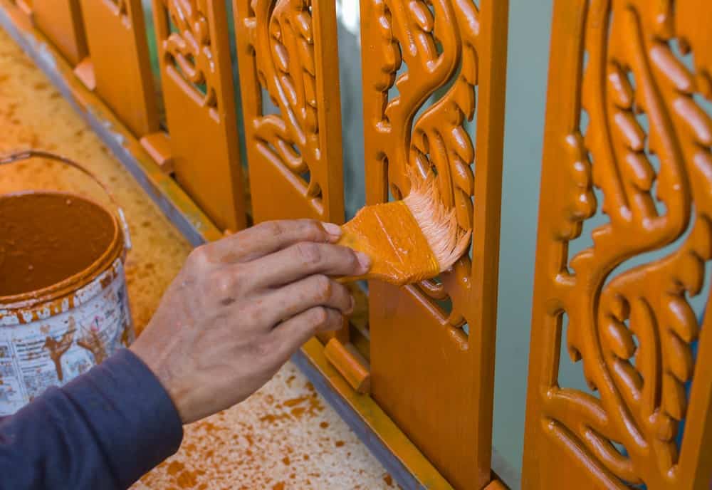 Piezas de barandilla de madera tallada pintadas con esmalte naranja.