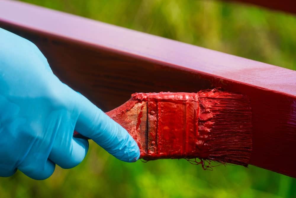 Un trozo de barandilla de madera pintado de rojo.