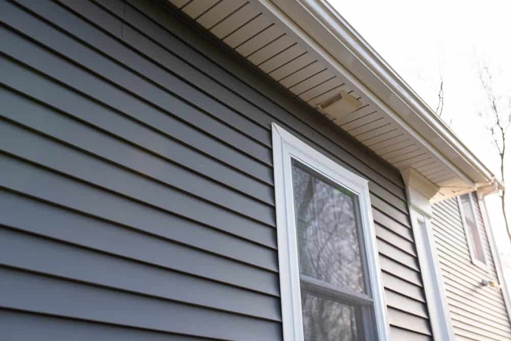 Detalle del revestimiento de vinilo gris oscuro del exterior de una casa.